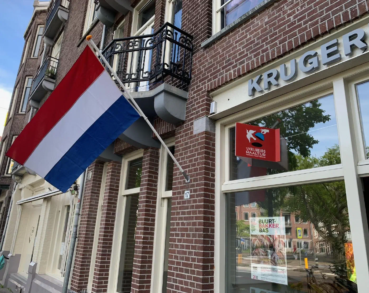 Gevel van de Kruger Kamer met Nederlandse vlag en bord van de Vrijheidsmaaltijd