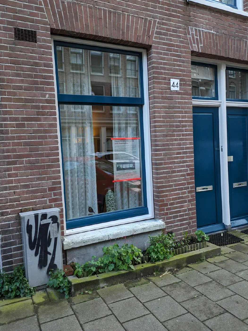 Gedenkposter achter het raam van Tweede Oosterparkstraat 44