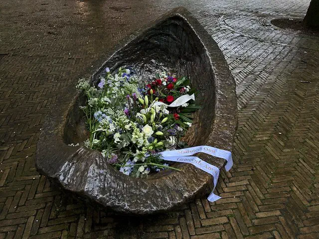 Bloemen met lint van Stadsdeel Oost in een bootvormige bronzen sculptuur