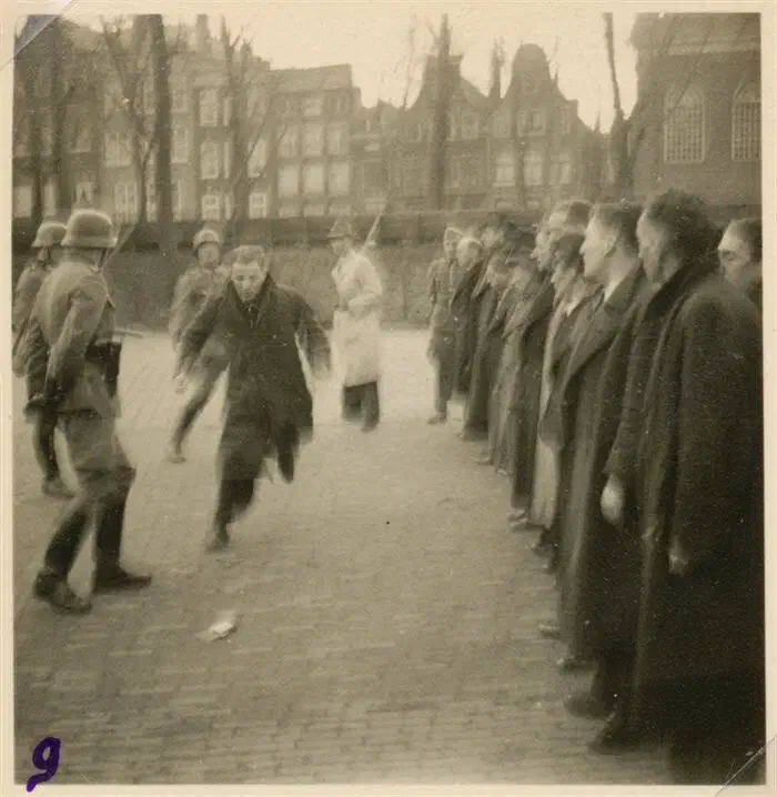 Duitse soldaten drijven opgepakte Joodse mannen samen tijdens de razzia van februari 1941