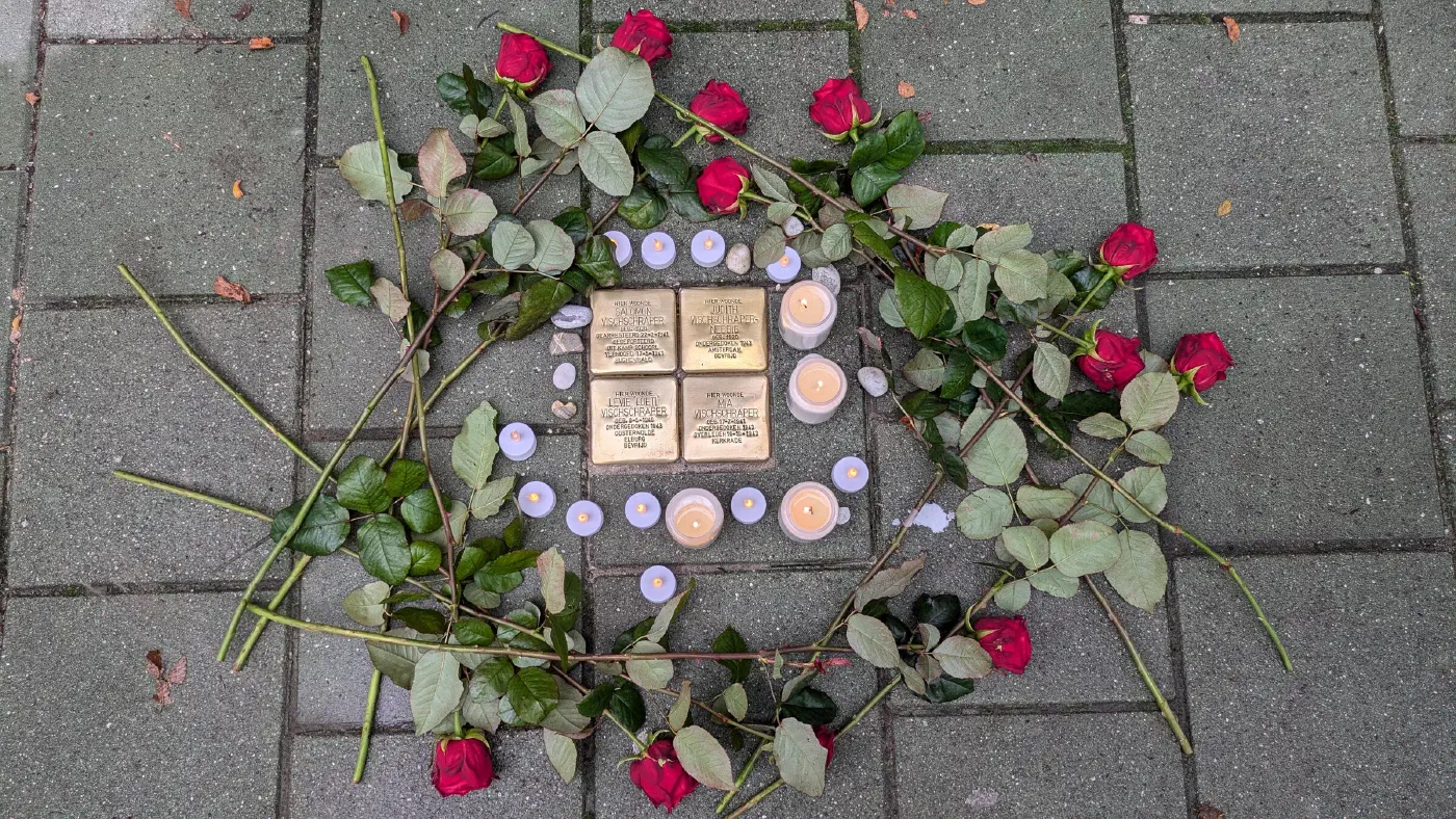 Door familie en buurtbewoners werden bij de struikelstenen lichtjes geplaatst en steentjes en bloemen gelegd.